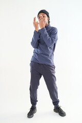 A young girl wearing sportswear clothes is posing on a white background.