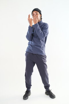 A young girl wearing sportswear clothes is posing on a white background.