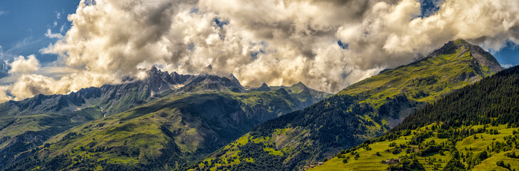 Summer mountain landscape with green peaks and cloudy sky