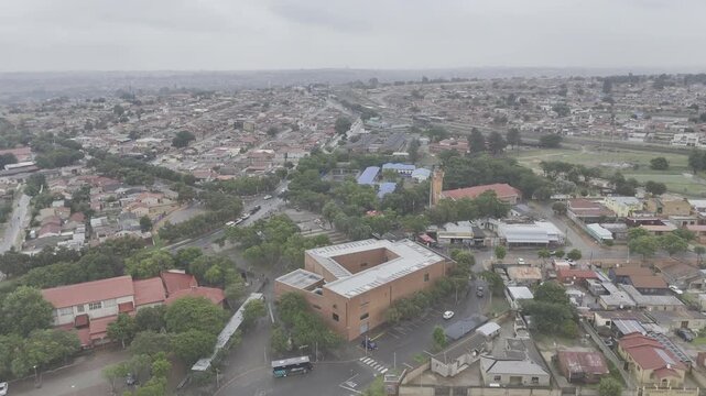 Drone flies south toward Hector Pieterson Memorial on rainy day in Soweto, South Africa