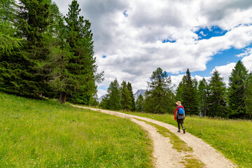 Woman hiker on tourist trail in Dolomites mountain
