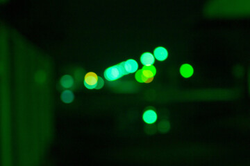 Soft green bokeh lights glowing in a dark corridor with shallow depth of field, creating a...