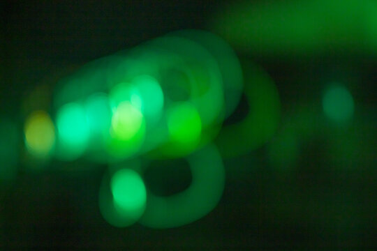 Abstract green light trails and soft bokeh blur on a dark background, evoking a futuristic, dreamy, and atmospheric feeling ideal for modern design, technology themes, and creative visuals. - Powered by Adobe
