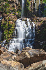 Fototapeta premium Breathtaking Multi-Tiered Waterfall with Silky Long Exposure Effect, Cascading Over Rocky Cliffs in a Lush Tropical Jungle Environment