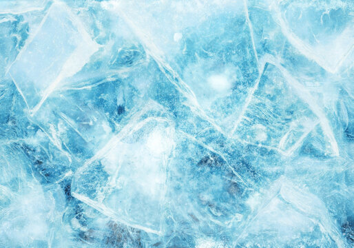 Crystal clear ice cubes background cool abstract texture with light blue to dark blue shades and scattered shiny frost