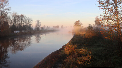 Hazy morning panorama with tranquil river