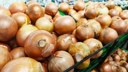 Close-up view of a pile of onions on a supermarket shelf