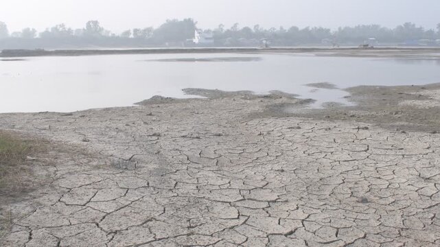 cracked dry riverbed showing water scarcity and drought conditions in rural india