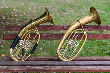 Two wind musical instruments on an old bench