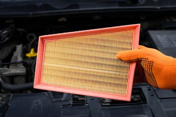 Auto mechanic holding a new air filter for car engine