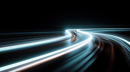 Bright light trails create dynamic patterns on a dark road at night. The scene captures movement and speed in an urban area. There is no visible traffic or landmarks.