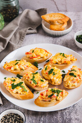 Baked sandwiches with crab salad and greens on a plate on the table vertical view