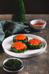 Original small sandwiches with butter and red caviar on a plate on the table vertical view