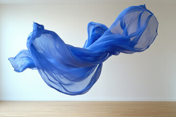 Light blue fabric flowing and floating in the air in minimalist room