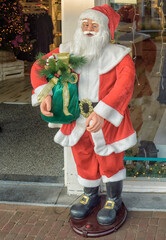 life-size moving Santa Claus statue stands outside a shop entrance