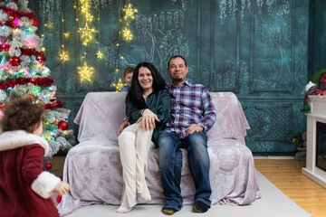 Naklejka premium happy family in front of Christmas tree