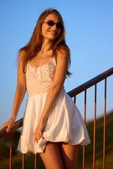 Slavic Woman in White Dress on Railing