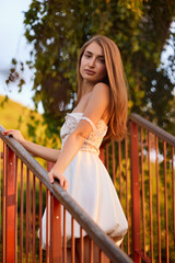 Slavic Woman in White Dress on Staircase