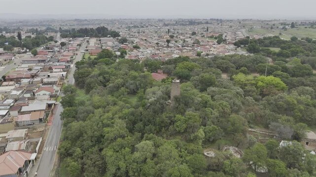 Drone flies over  Credo Mutwa Cultural Village and the Orlando neighborhood on overcast day in Soweto, South Africa