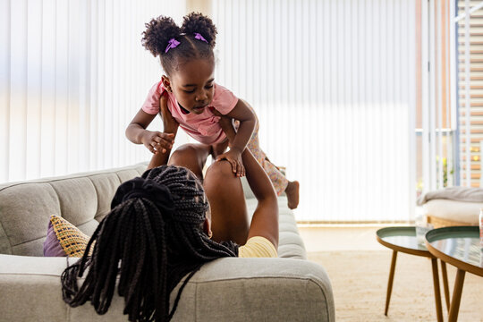 Playful bonding time at home between black mother and child