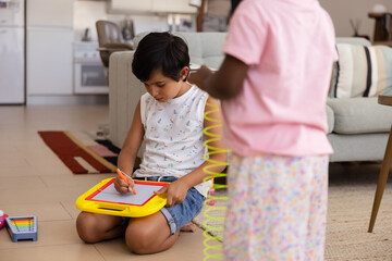 Multiethnic children engaged in creative play at home on the floor
