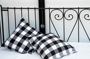 Two Black and White Checkered Pillows on a Bed