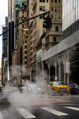 NYC street steam rising from manhole on Fifth Avenue in Manhattan winter