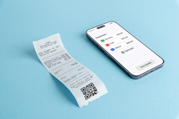 Smartphone showing expenses overview dashboard next to paper receipt on blue background, illustrating mobile finance app, bookkeeping software, and digital expense tracking