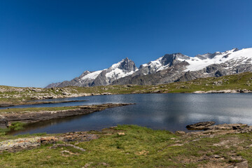 Naklejka premium Lac Noir with a scenic view of La Meije peak on the Emparis Plateau in the Arves Massif, Hautes-Alpes, France.