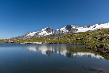 Lac Noir with a scenic view of La Meije peak on the Emparis Plateau in the Arves Massif, Hautes-Alpes, France.