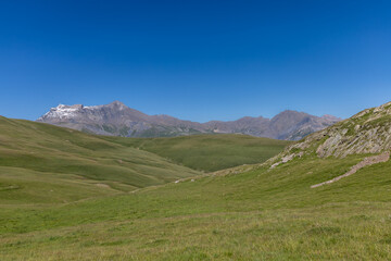 Fototapeta premium Mountain view of the Emparis Plateau in the Arves Massif, Hautes-Alpes, French Alps, featuring rugged peaks and alpine meadows.