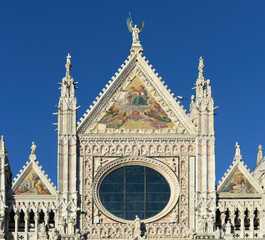 Naklejka premium Front top gable of the medieval cathedral or duomo of Siena with blue sky on a bright october day in Tuscany, Italy