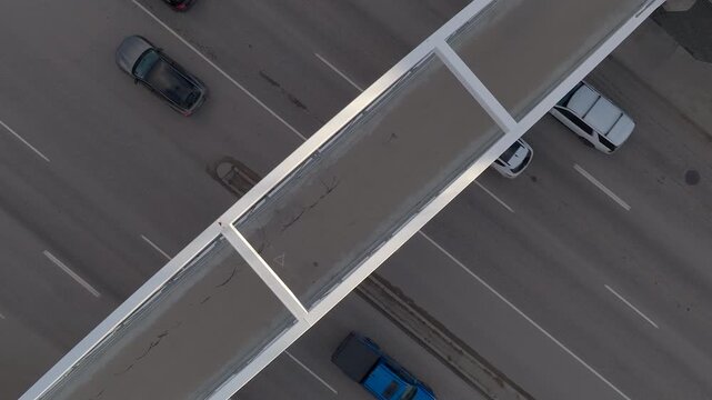 Empty pedestrian overpass with busy multilane road below