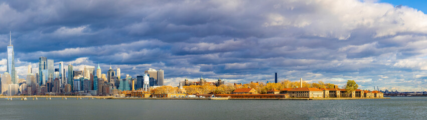 Ellis Island with Lower Manhattan skyline across New York Harbor, NYC USA