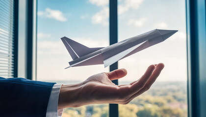 Businessman launching paper airplane from hand in modern office  