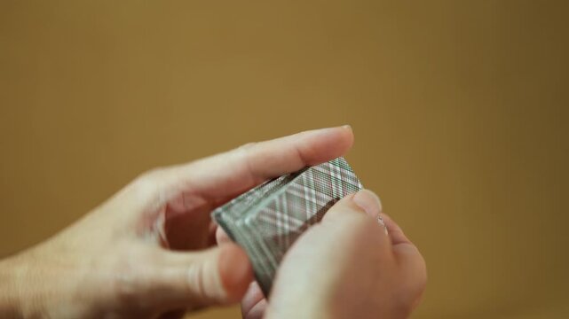 Close up of professional magician hands shuffling playing cards. Skilled magician hands performing a complex shuffle with a deck of playing cards, demonstrating sleight of hand and dexterity