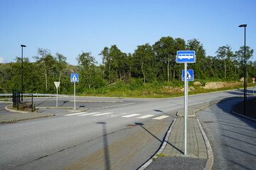 Pedestrian Crosswalk and Bus Stop on a Quiet Suburban Road in Norway. The unregulated pedestrian crossing is equipped.