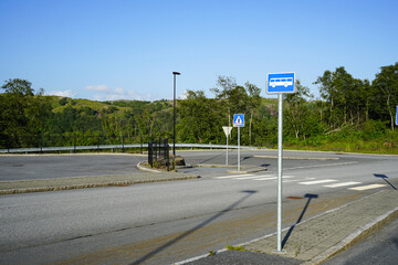 Pedestrian Crosswalk and Bus Stop on a Quiet Suburban Road in Norway. The unregulated pedestrian crossing is equipped.