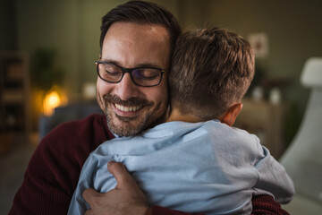 Fototapeta premium Happy father embracing son expressing love and family bonding