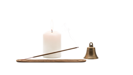 Serene meditation setup with a burning candle, incense stick, and a small brass bell on a white background