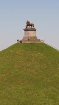 visitors top stairs platform lion's mound waterloo belgium perspective grandeur reveals from dynamic drone panning shot view leeuw van monument landscape 