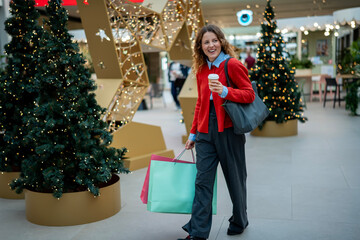 Cheerful young woman enjoying holiday shopping in mall