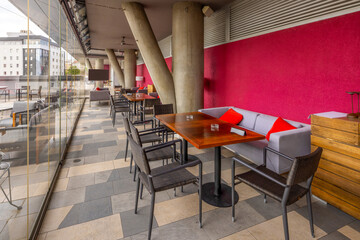 Outdoor patio featuring comfortable chairs divided with glass wall