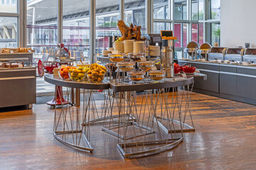 Bright breakfast room interior with buffet tables laden with assorted dishes