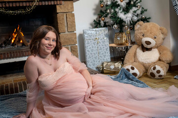 femme enceinte juste avant no&euml;l devant un beau sapin