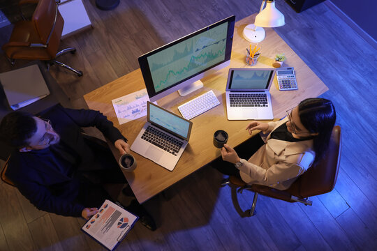 Business analysts with cups of coffee working at table in office, top view. Data science concept - Powered by Adobe
