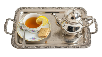 Close up overhead of a tray with a teapot, cup, and saucer arranged for afternoon tea isolated on white background
