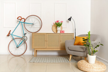 Interior of living room decorated for Women's Day with bicycle and armchair