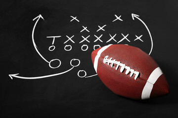 Rugby ball and scheme of American football game drawn on chalkboard as background