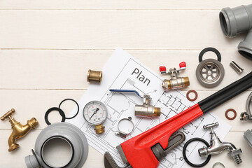 Composition with plumber's items with house plan on white wooden background